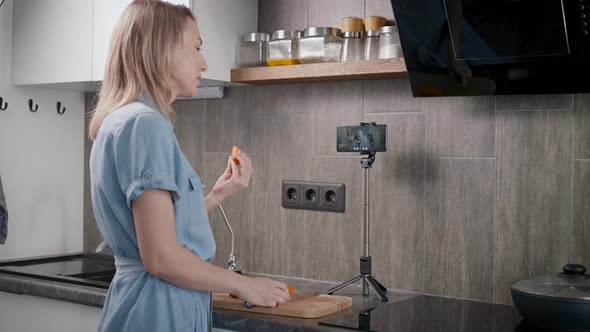 A Housewife in Her Kitchen Prepares Food and Communicates Online alt