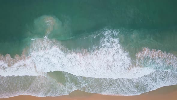 Top View of the sea surface Waves crashing on beach sand alt