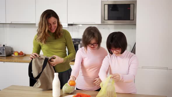 Down Syndrome Girls with Mother on Kitchen After Shopping Slow Motion alt