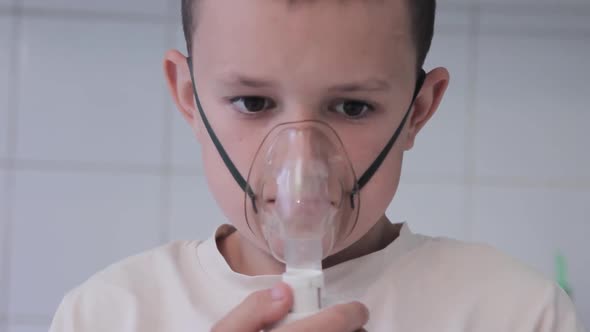 Young boy breathes inhaler at home. Get treated for colds and flu