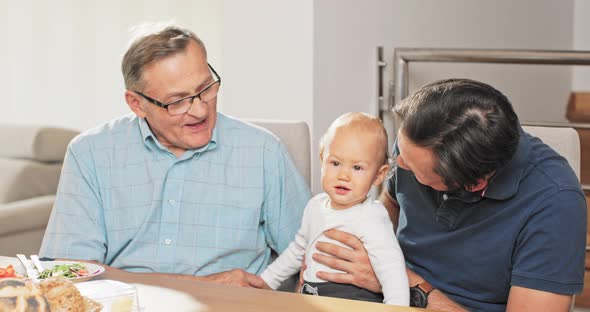 The Loving Caring Father Holds His Child on His Lap Grabs His Hand Shakes His alt