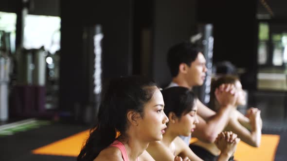 Group of Athletic Young Asian People in Sportswear Doing Squat and Exercising at the Gym alt