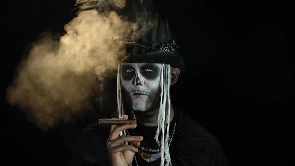 Sinister Man with Horrible Halloween Skeleton Makeup Smoking Cigar, Making Faces, Looking at Camera alt