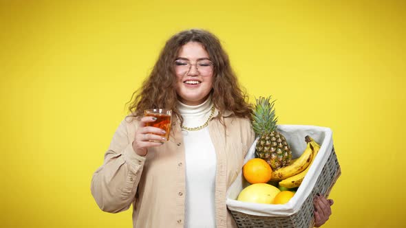 Young Brunette Overweight Lady in Eyeglasses Drinking Juice Toasting with Camera Holding Organic alt
