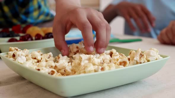 Child Hands Grabbing Popcorn alt