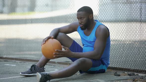 Nervous Man in Sportswear Sitting Alone Near Stadium and Holding Ball Loser alt