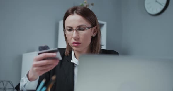 Young Woman Hold Bank Credit Card in Hand and Buying From Computer