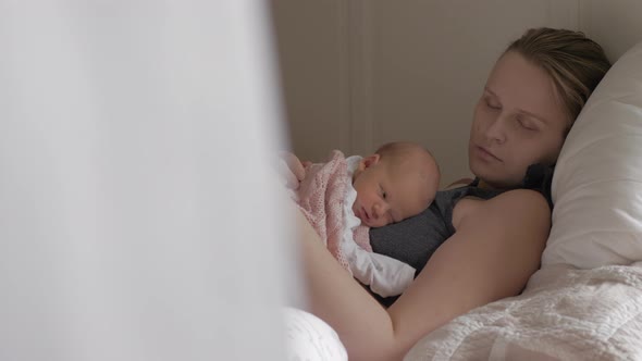 Young Mother Sleeping with Newborn Daughter alt