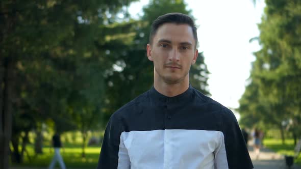 Handsome Young Man Walking on the Street and Looking at Camera alt