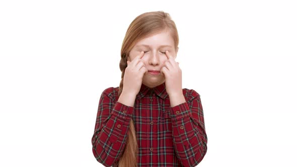Cute Funny Caucasian Elementaryschool Aged Girl Standing on White Background Making Faces and alt