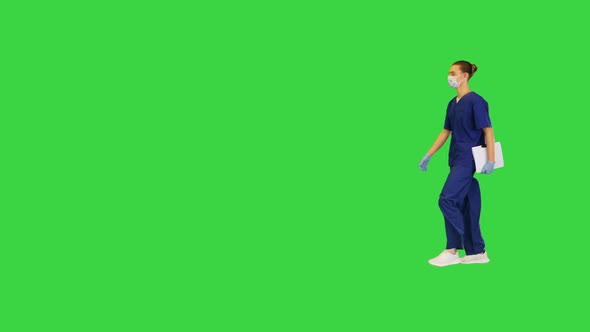 Young White Doctor Walks with Documents in His Hand on a Green Screen Chroma Key