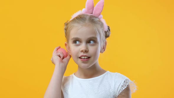 Pretty Little Girl in Cute Headband Shaking Egg and Listening to Sound, Fun alt