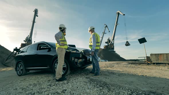 Specialists Are Talking Near a Car in the Industrial Facility. alt