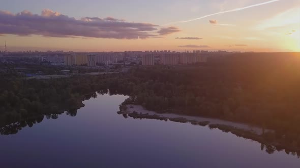 Flight Over the Lake During Sunset Overlooking the City with Beautiful Clouds, Ukraine Kiev.