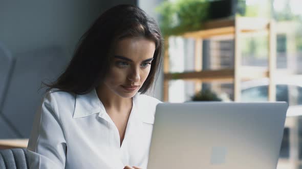 Young and Smart Woman Freelancing in Modern Cafe alt