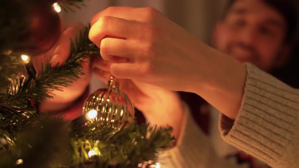 Happy Couple Decorating Christmas Tree at Home alt