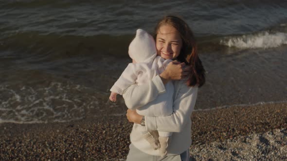 Mom with Her Newborn Daughter at the Sea