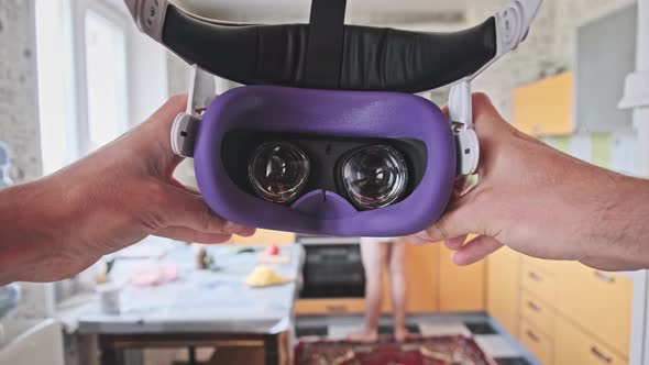 Man Taking On VR Helmet at Home Kitchen Point of View alt
