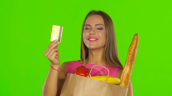 Girl in the Calculation for the Products Used the Gold Card. Green Screen. Close Up alt