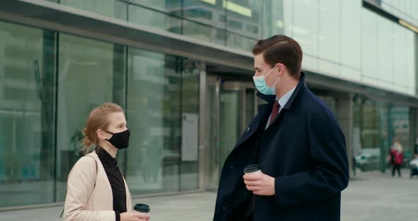 Business People in Masks Meet with Fist Bump Knuckle Greeting By Office Building