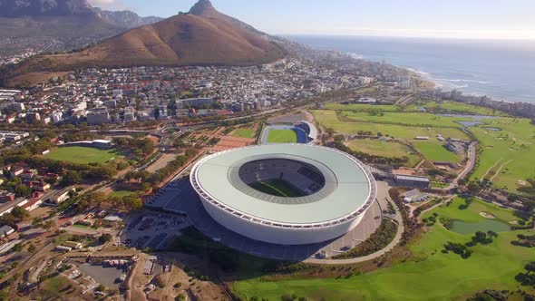 Aerial travel drone view of Cape Town, South Africa with Table Mountain and stadium. alt