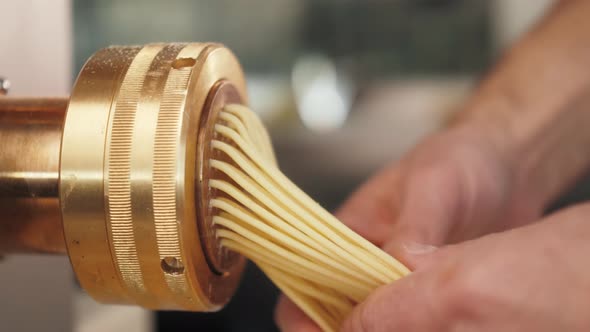 Man Making Fresh Pasta on Traditional Italian Kitchen Machine for Spaghetti Chef Preparing Fresca alt