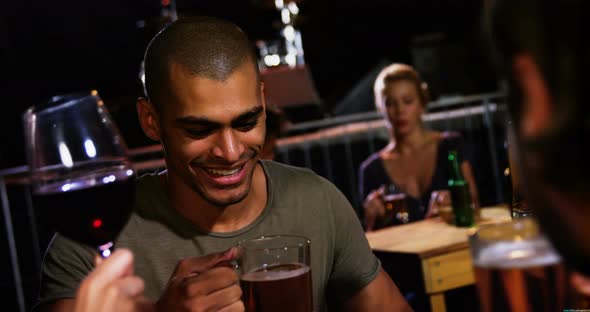 Group of friends toasting beer mugs at a concert 4k alt