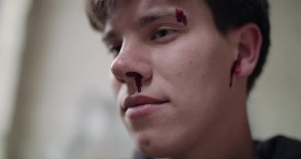 Close Portrait of Wounded Bloodied Man Looking Shockingly at the Camera alt