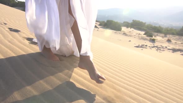 White Dress woman walking on the desert sand