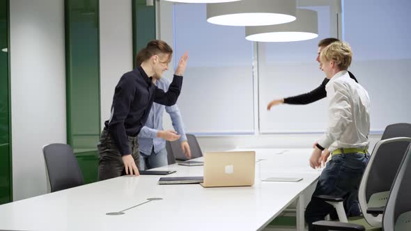 Wide Shot of Cheerful Business Partners Standing Up in Conference Room and Shaking Hands alt