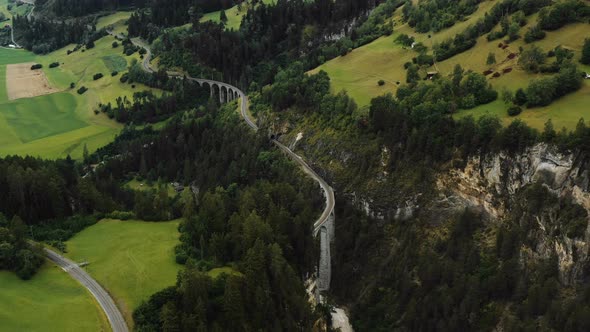 Amazing Panoramic Aerial Shot of Famous Swiss Alps Railway Passes, Epic Zoom in on Famous Landwasser