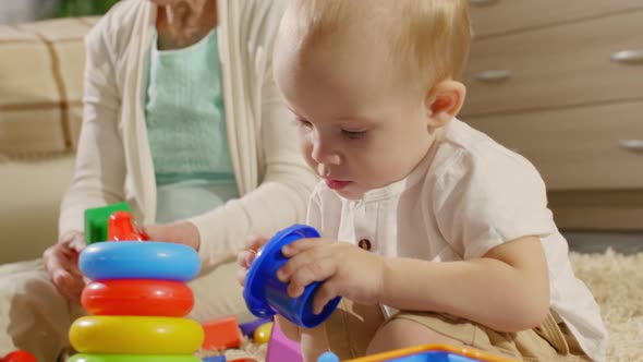 Adorable Child and Grandmother Playing Together at Home