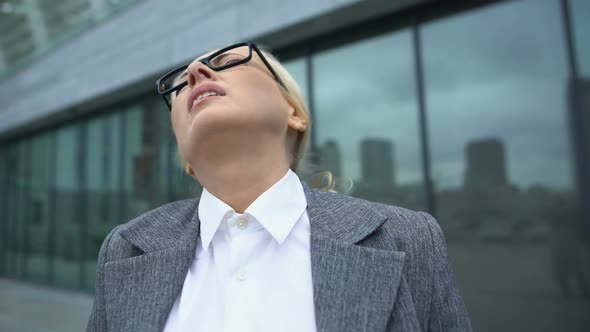 Mature Female Boss in Eyeglasses Turning Head, Suffering Neck Pain Outdoor, Ache