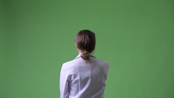Rear View of Young Beautiful Woman Doctor Pointing Finger and Directing alt