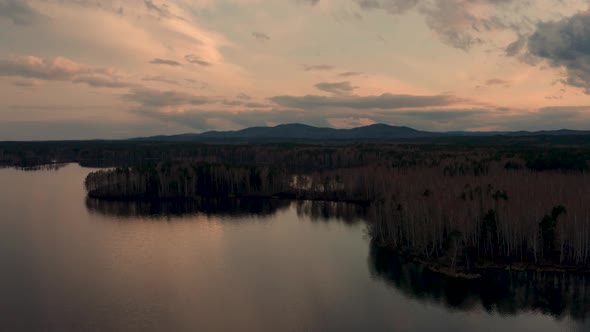 Aerial View of the Natural Landscape Forest on the Lake Shore at Sunset alt