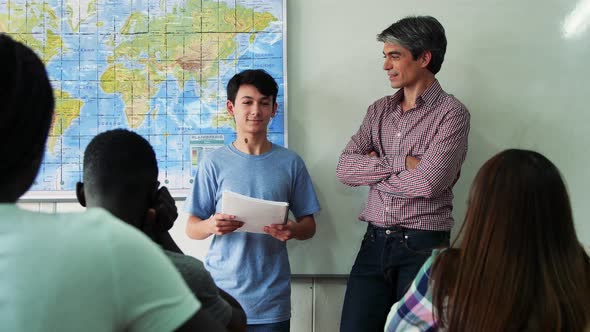 Teacher Interviewing Boy in a Multiethnic Teenager Classroom. Slow Motion alt