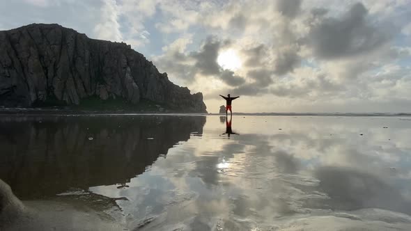 Freedom, guy walking at the beach in morro bay california, iconic morro bay rock, water reflection alt