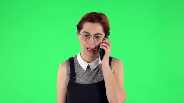Portrait of Funny Girl in Round Glasses Is Angrily Talking for Mobile Phone, Proving Something alt