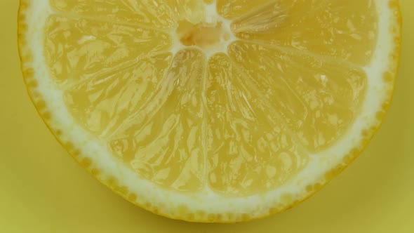 Lemon Cut In Half Rotates On a Yellow Background alt