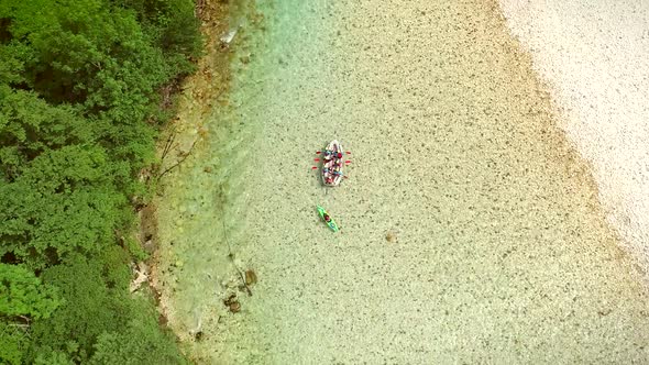 Aerial view of a group of people doing rafting turquoise and transparent water. alt