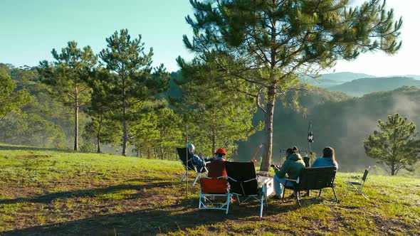 Group of friends sitting outside relaxation enjoying coffee and nature on the hills concept