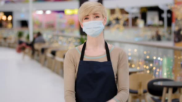 Mature Adult Middle Aged 40s Woman in Medical Mask Restaurant Cafe Worker Looking at Camera Crossing alt