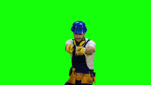 Builder Holds Two Roulettes in His Hands and Twists Them in Different Directions. Green Screen alt