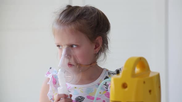 Little girl makes an inhalation vapor .
