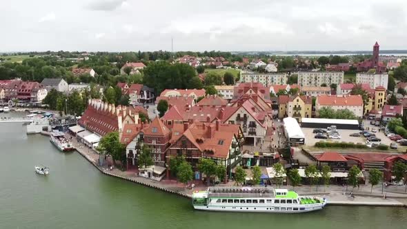 Panorama over the Mikolajskie lake and Mikolajki in Poland. aerial drone flight over the pedestrian alt