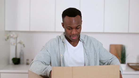 Happy Attractive African American Guy Unpacks His Long Awaited Package Examines the Clothes That He alt