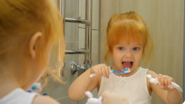 Little Girl f Brushing Her Teeth with a Toothbrush in Bathroom in the Morning