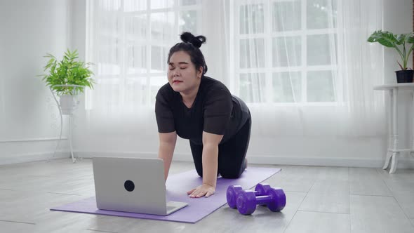 Plus size women are exercising online to lose weight in the living room