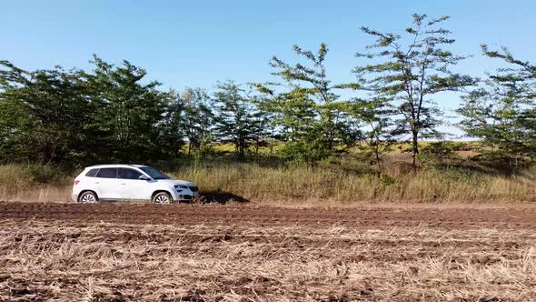 is a Car That Drives at High Speed on a Rural Road in a Field alt