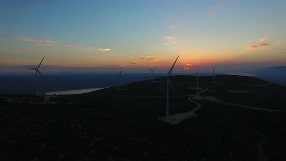 Aerial view of white elegant windmills at sunset alt